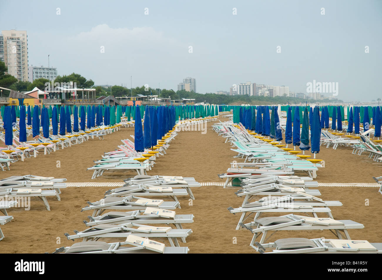 Las tumbonas y sombrillas cerradas en la playa de Lignano Sabbiadoro, Italia Foto de stock