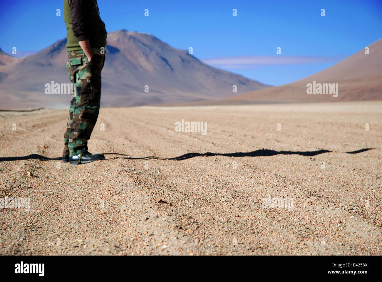 Hombre de pie sobre la arena de Eduardo Avaroa Reserva Nacional de Fauna Andina, Bolivia Foto de stock