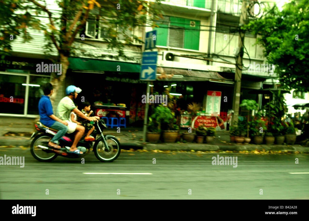 Familia de tres compartiendo una moto en Bangkok, Tailandia Foto de stock
