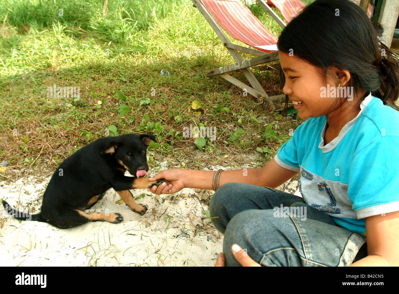 Niña jugando con Puppy, Sihanoukville, Camboya Foto de stock