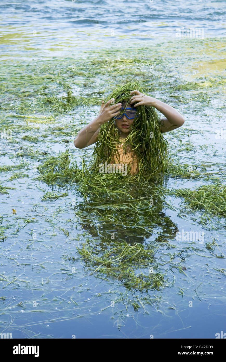 Un joven hasta la cintura en el río cubre a sí mismo en la maleza durante un juego Fotografía de Un joven hasta la cintura en el río cubre a sí mismo en la maleza durante un juego Fotografía de