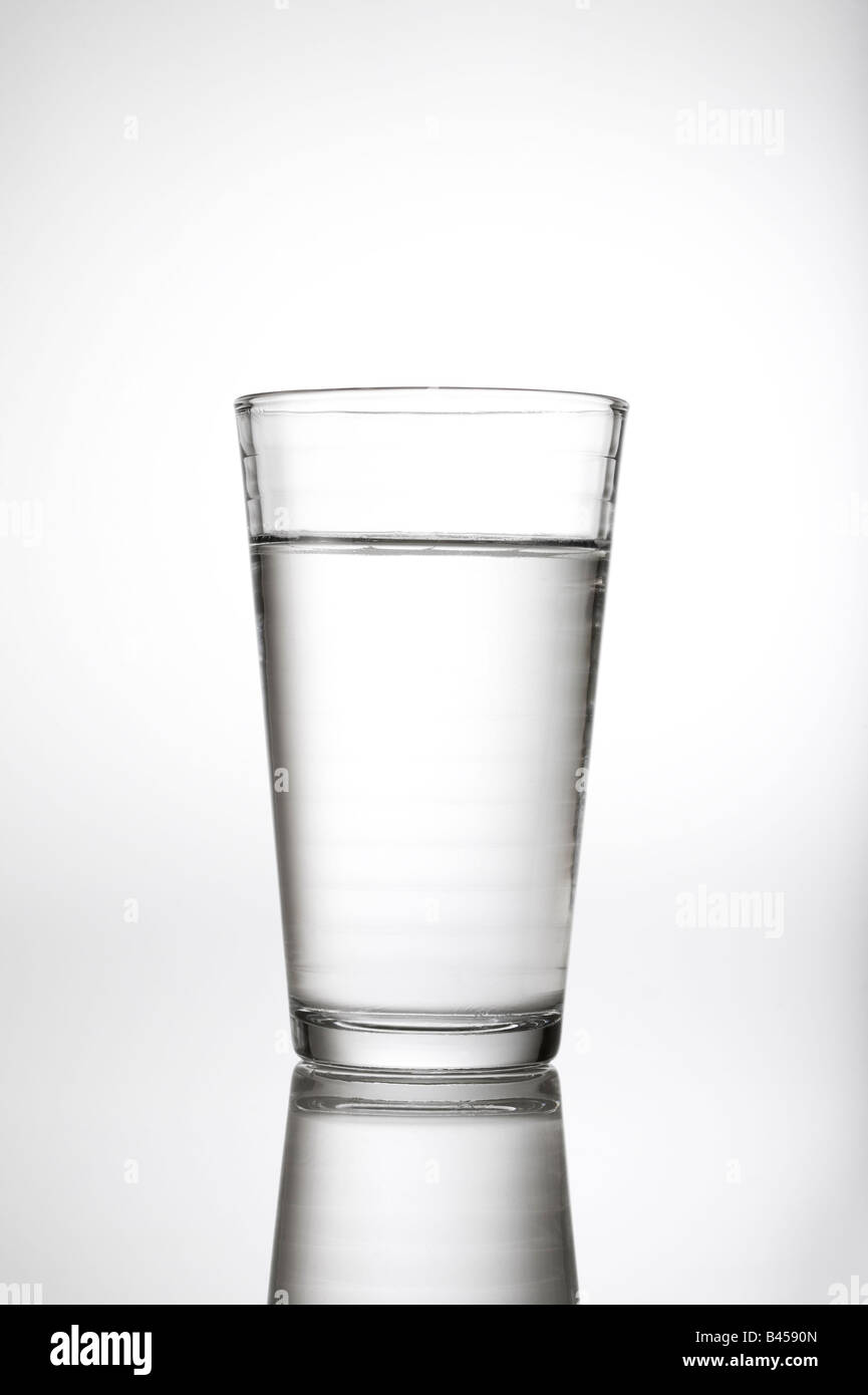 Vaso de agua h2o en estudio de fondo blanco con reflexión. Foto de stock