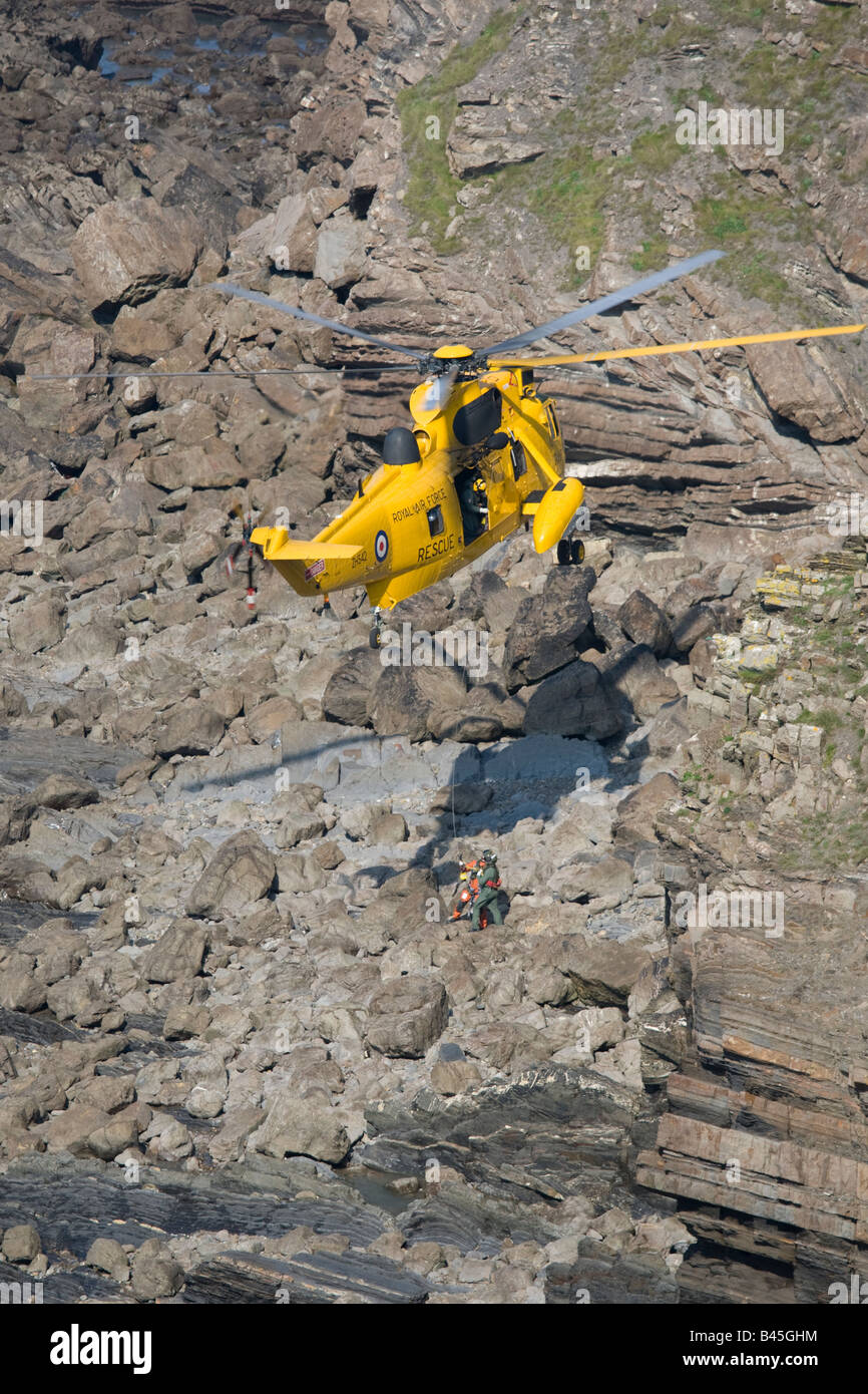 RAF helicóptero de rescate en el mar de aire por encima de rocas en la Bahía de Widemouth Bude Cornualles UK Foto de stock