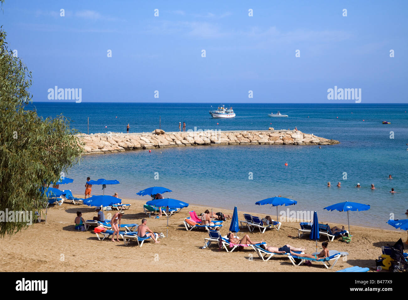 Vista de pernera playa cerca de Paralimni, PROTARAS, CHIPRE CON MUCHOS paraguas azul y dorada arena Foto de stock