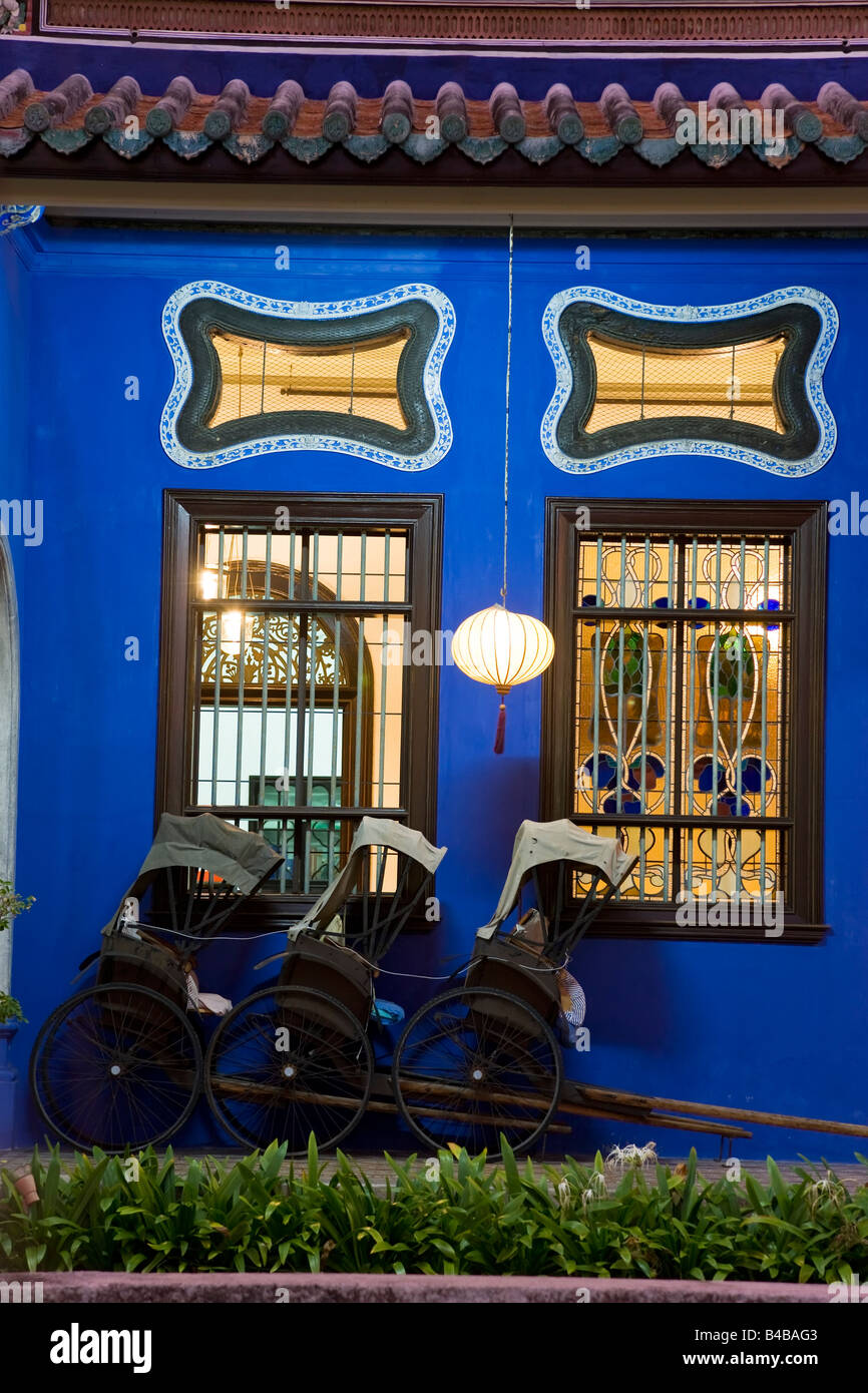 Asia, Malasia, Penang, Pulau Pinang, Georgetown, el barrio de Chinatown, detalle de Trishaws alineados contra una pared pintada de azul Foto de stock