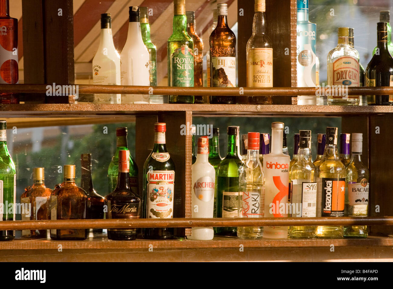 Botellas de en una fila en un estante bar Fotografía stock - Alamy