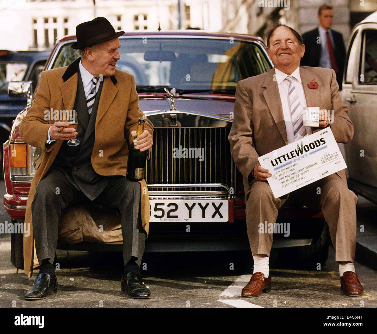 Christopher Hill Littleswoods piscinas ganador sentado en coche Rolls Royce paragolpes con el actor George Cole vestida como Arther Daley tras presentar Christopher con un cheque por 2 008 137 62p Foto de stock
