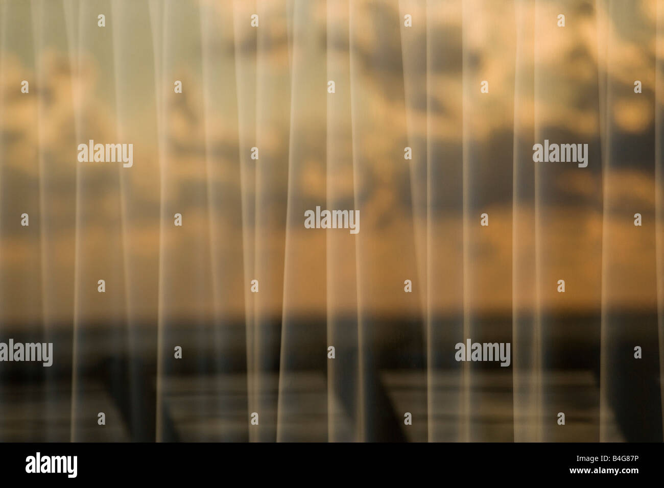 Reflejo de un cielo nublado en el panel de ventana con cortinas Foto de stock