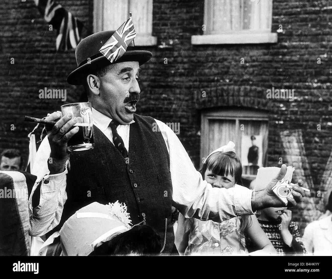 Warren Mitchell Actor como Alf Garnett Julio de 1968 en el programa de televisión "hasta que la muerte nos separe" vistiendo un sombrero con una Union Jack en mantener una bebida y un cigarro hablando y gesticulando en una manera borracho Foto de stock