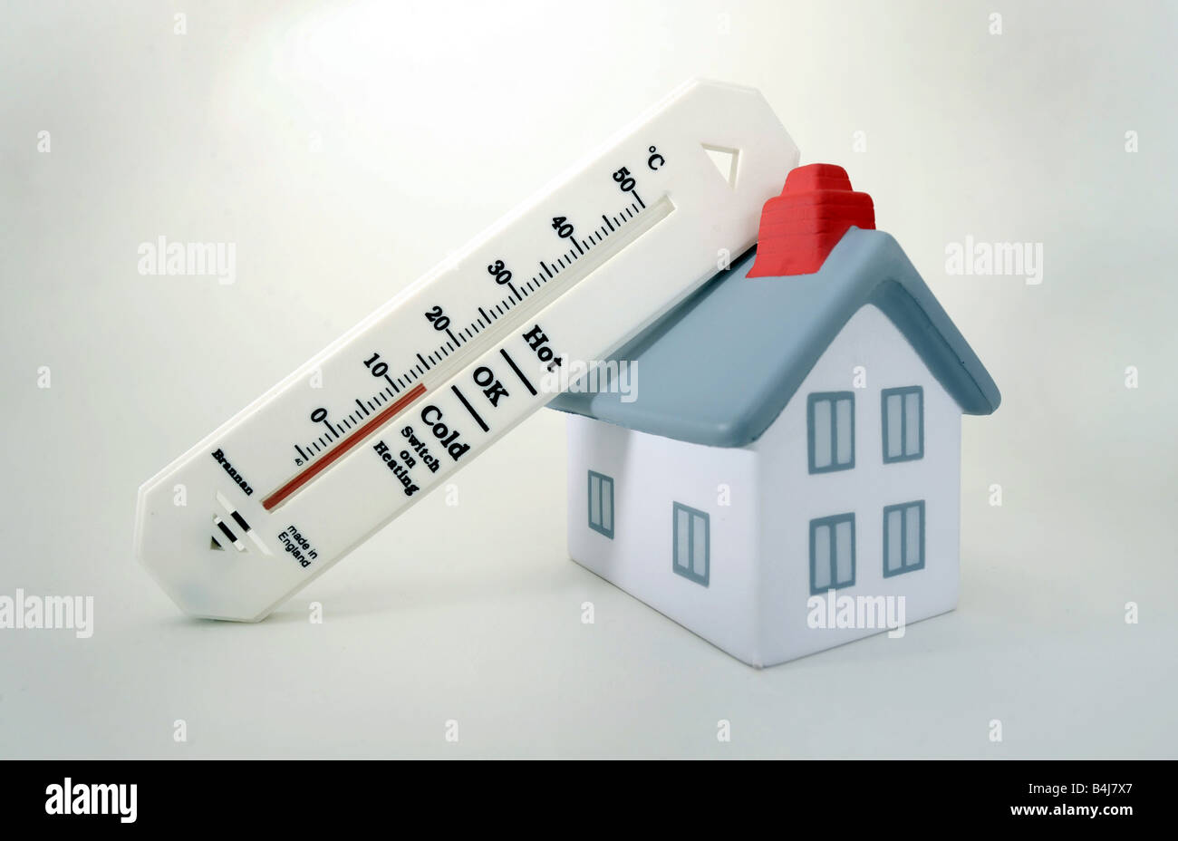 Casa modelo con termómetro de temperatura fría, encienda la calefacción! Foto de stock