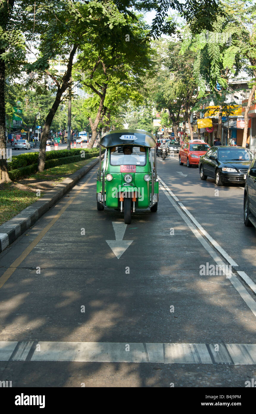 Un tuk tuk o rickshaw motorizado venir a descansar en un semáforo Bangkok Thailand Foto de stock