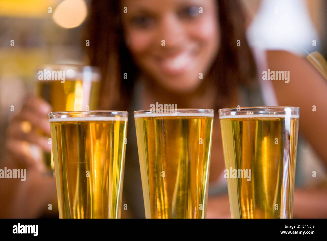 Mujer posando con varios vasos de cerveza Foto de stock