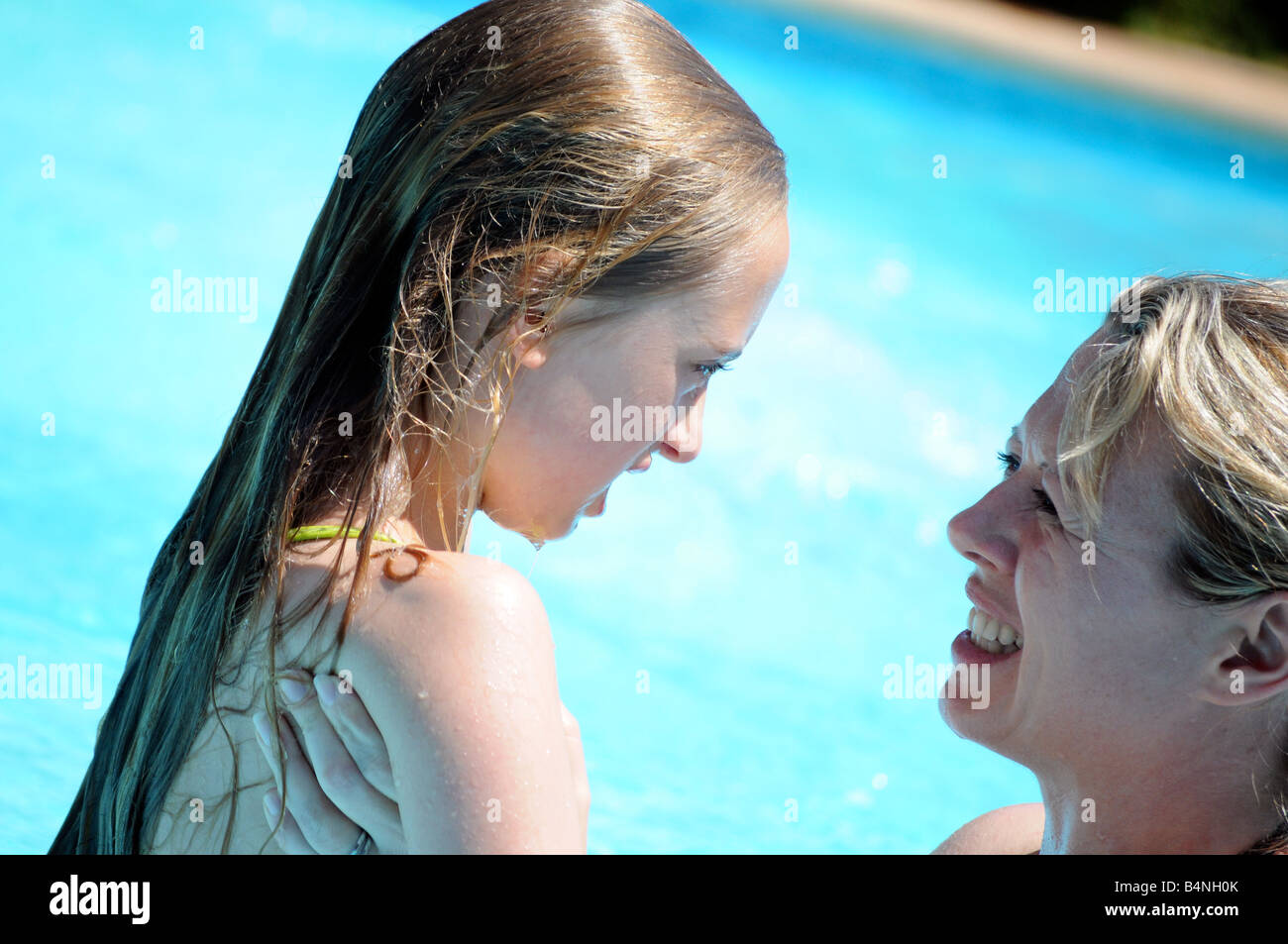 Fotografías royalty free de niña jugando en la piscina de vacaciones y hablando con su madre madre. Foto de stock