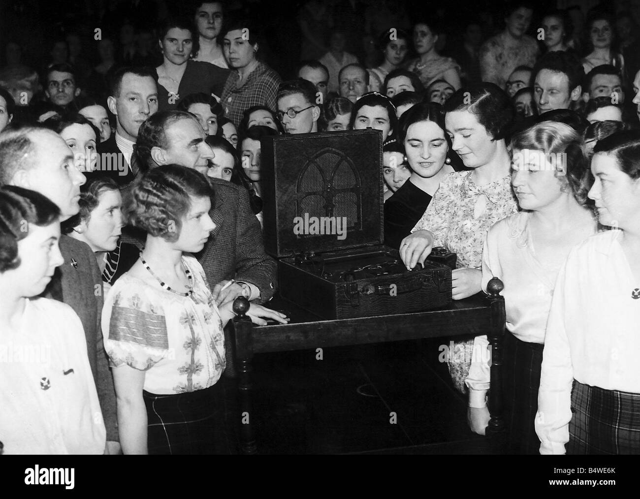 Una multitud de personas amontonadas alrededor de un inalámbrico para escuchar el rey Eduardo V111 s Discurso de abdicación el 11 de diciembre de 1936, la difusión en todo el mundo se muestra en teatros y cinames británicos fueron detenidos por personas de pie alrededor de MSI dbase viejo radio Foto de stock