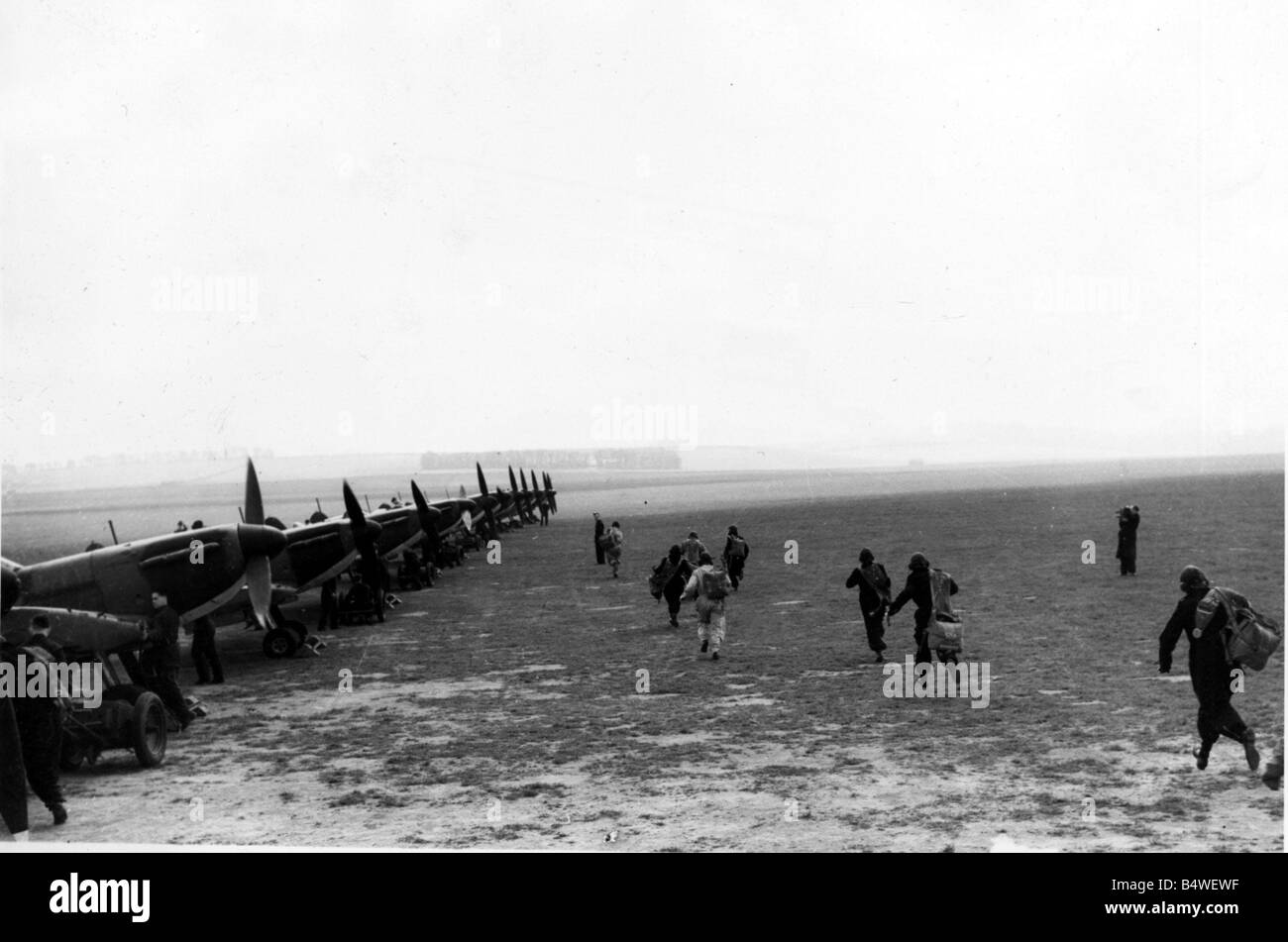 Segunda Guerra Mundial Batalla de Bretaña imagen muestra los pilotos en el crepúsculo corriendo a la cabina de los aviones de combate de su sala de descanso en el aeródromo como carrera para satisfacer la aviación alemana 1941 Foto de stock