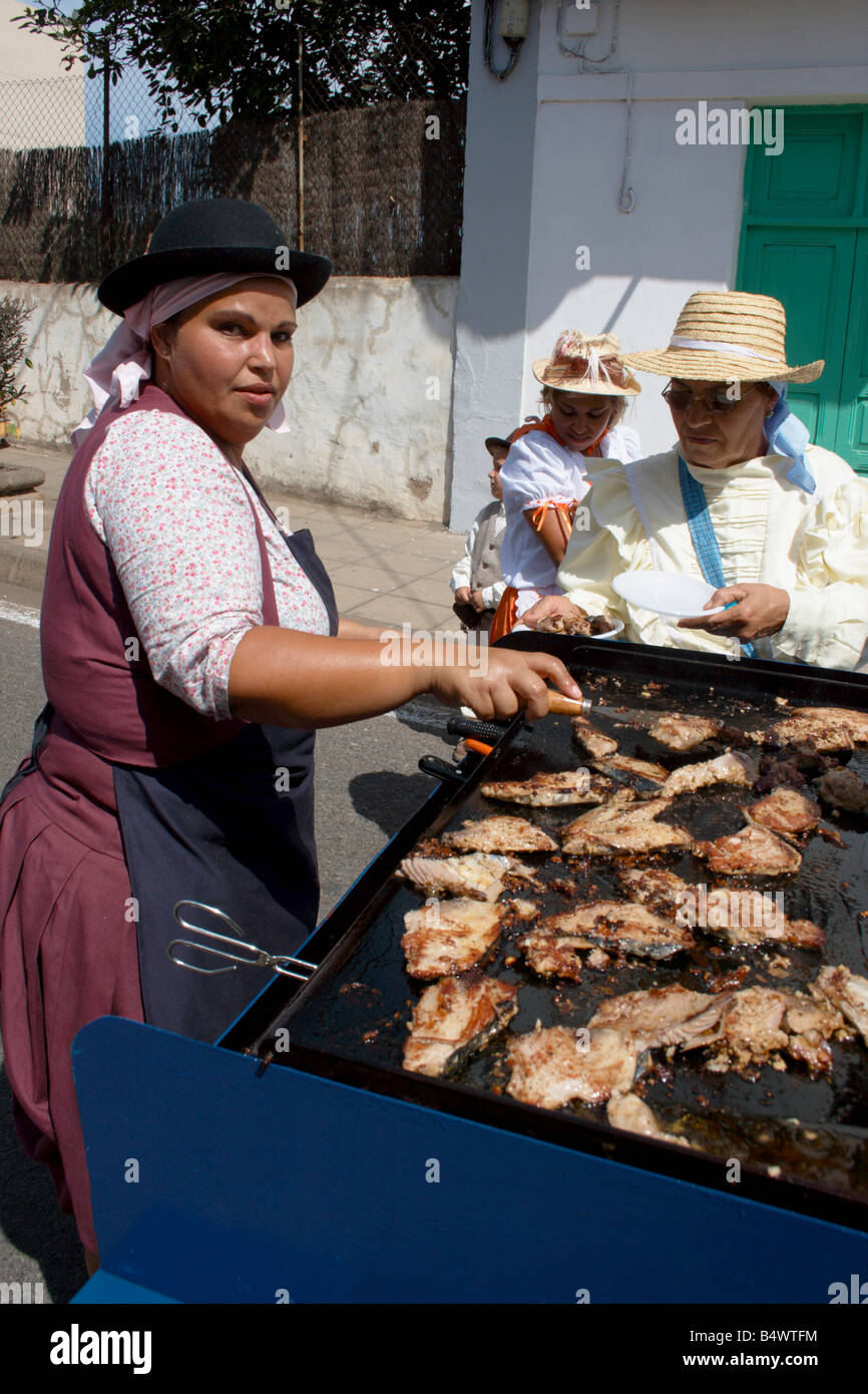 Mujer española cocina filetes de atún fresco en las fiestas del Pino en Teror en Gran Canaria en las Islas Canarias Foto de stock