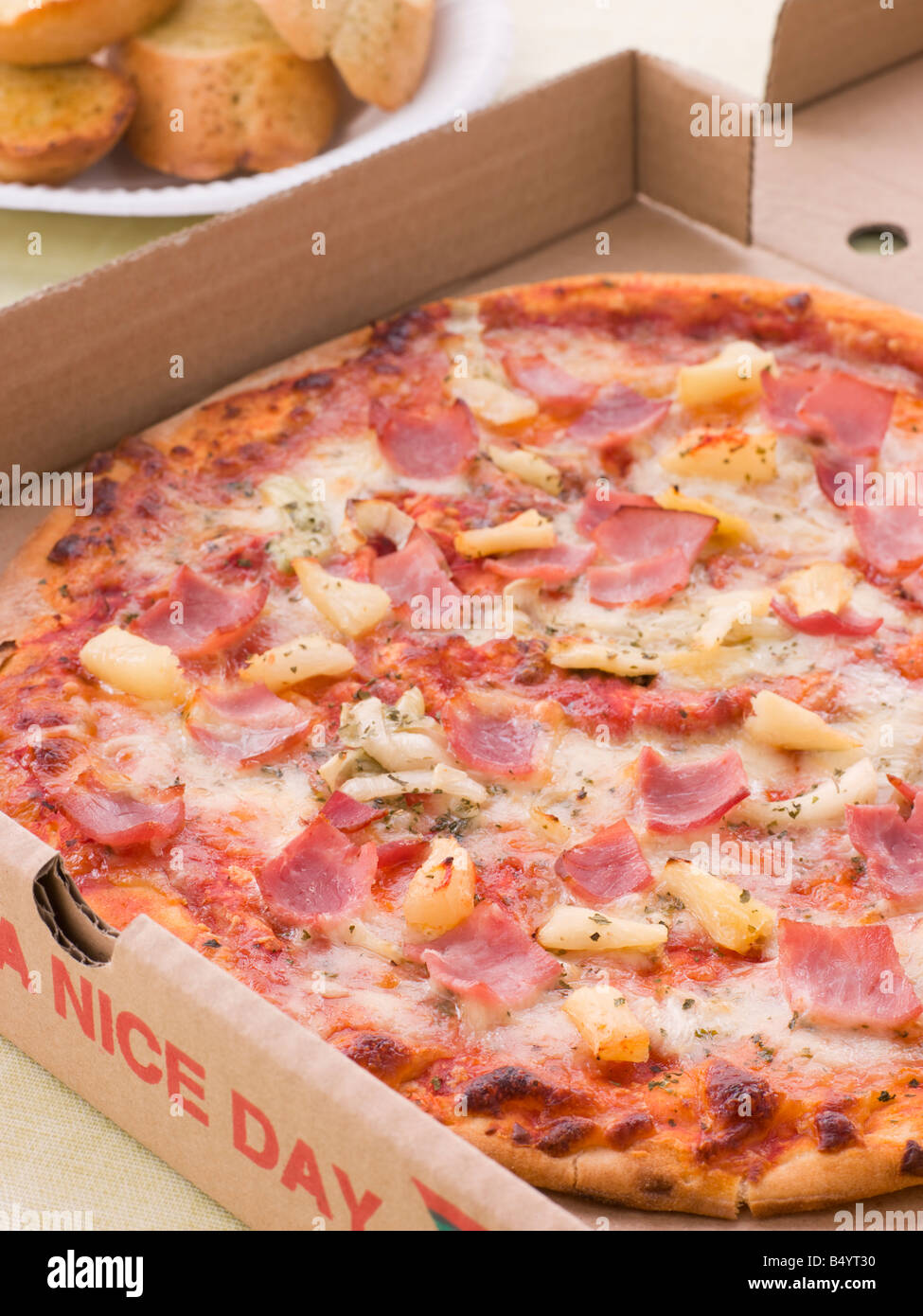 Pizza hawaiana en Llevar Caja con pan de ajo Foto de stock