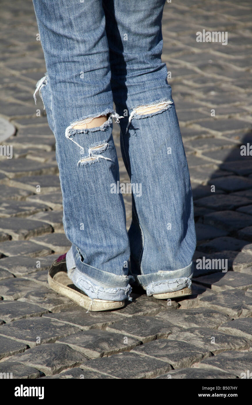 Persona joven con pantalones vaqueros rasgados de pie en la calle en la  ciudad Fotografía de stock - Alamy
