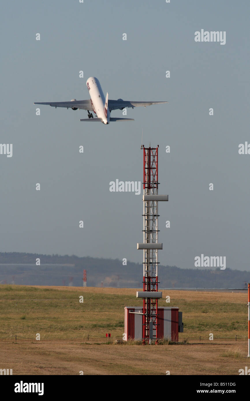 ILS (Instrument Landing System) antena en el aeropuerto de Lisboa, con el avión de pasajeros Boeing 757 despegando en la distancia. La tecnología en la aviación. Foto de stock