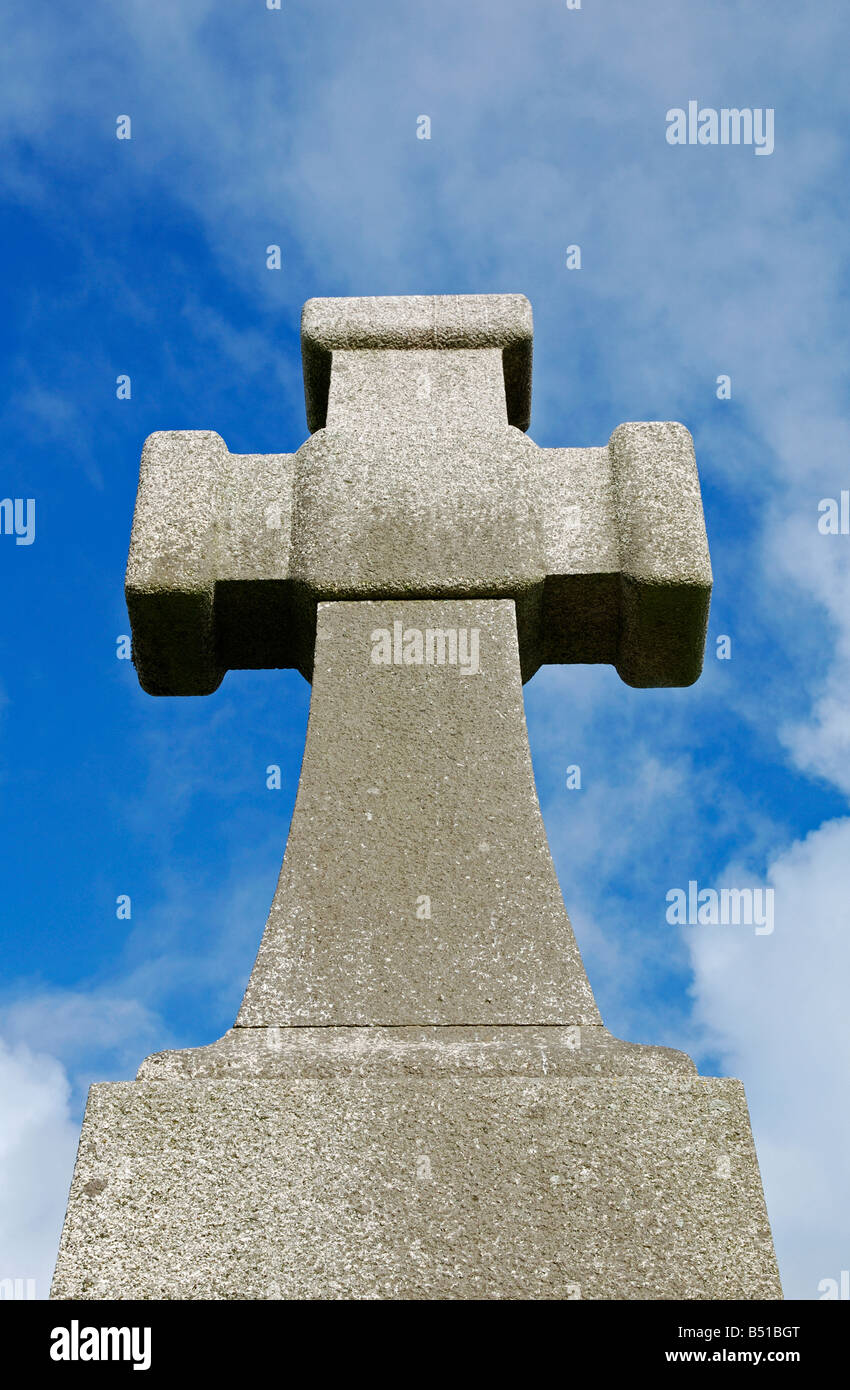 Una gran cruz de piedra de granito contra un cielo azul Foto de stock