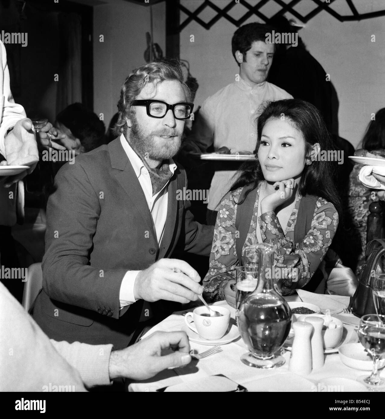 Fotógrafo David Bailey ha celebrado hoy una fiesta en un club de Chelsea Kings Road para lanzar su libro asistieron a la fiesta. Michael Caine con su novia Minda Feliciano. Noviembre de 1969 Z10810-002 Foto de stock