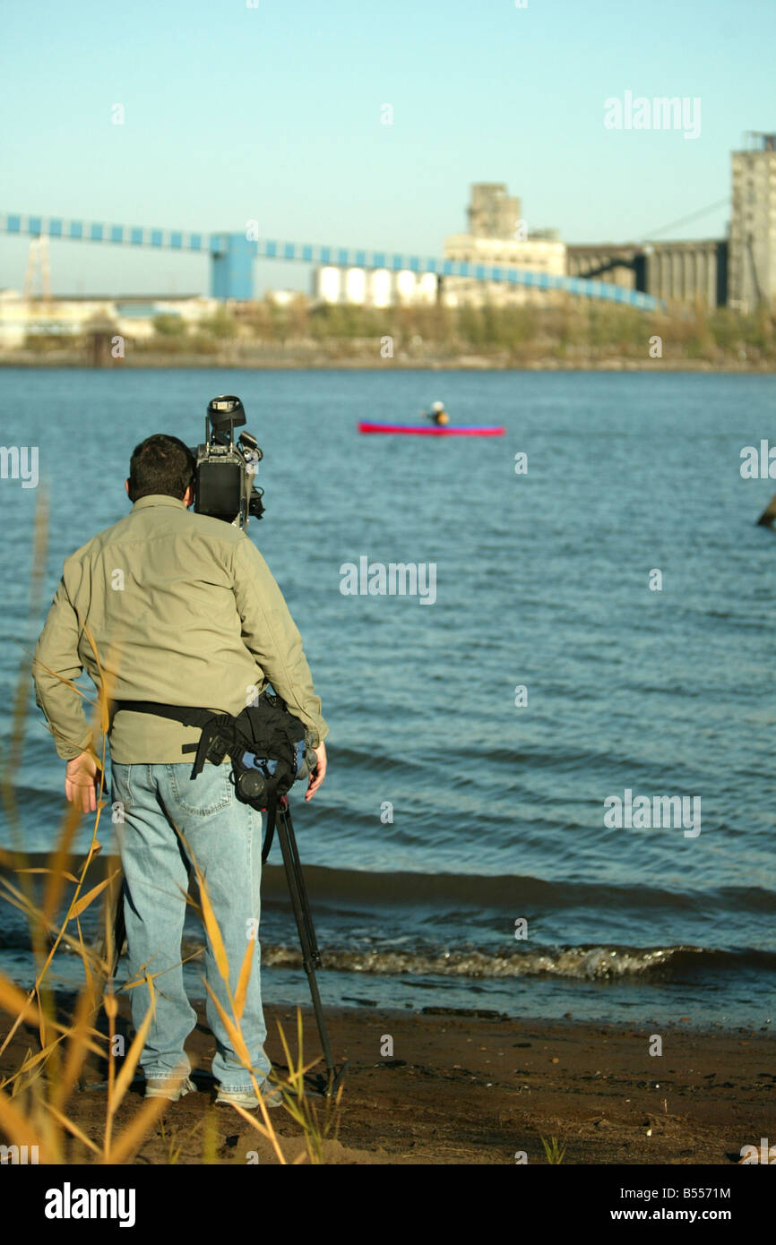 Un camarógrafo de noticias de televisión filmando un kayak en el Río Columbia, Oregon. Foto de stock