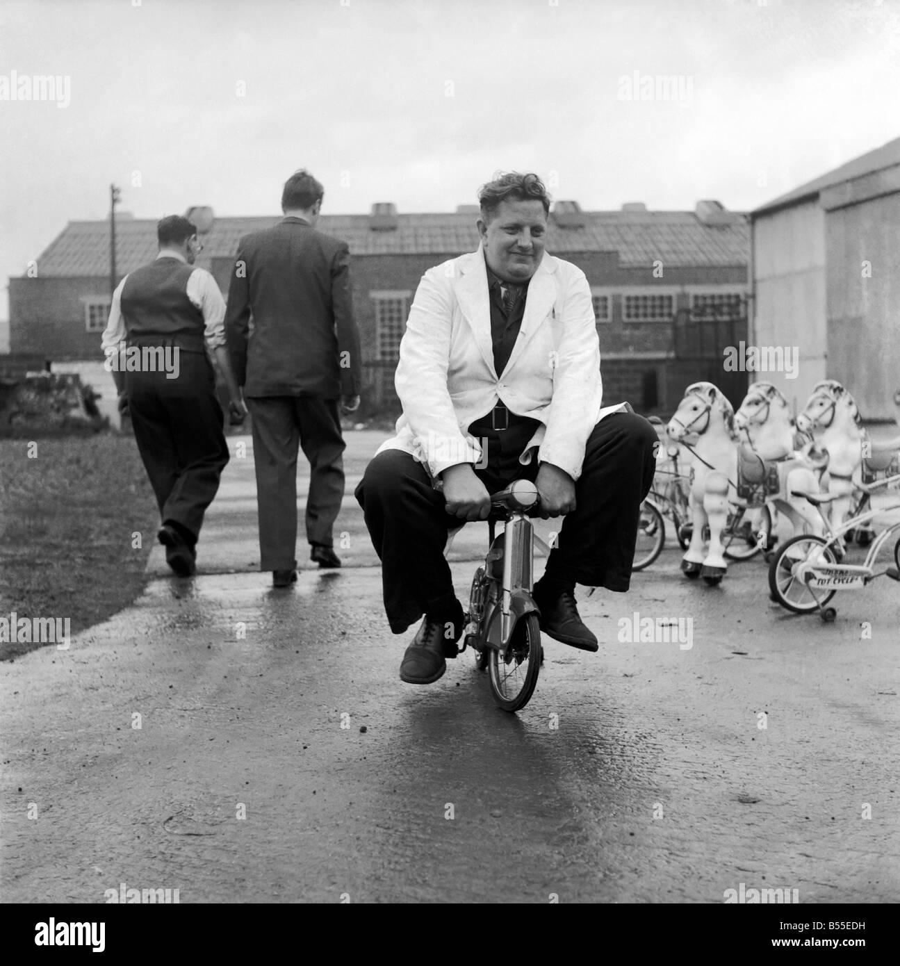 hombre-probando-los-juguetes-para-ninos-bicicletas-y-caballos-de-balanceo-de-diciembre-de-1953-d7321-b55edh.jpg