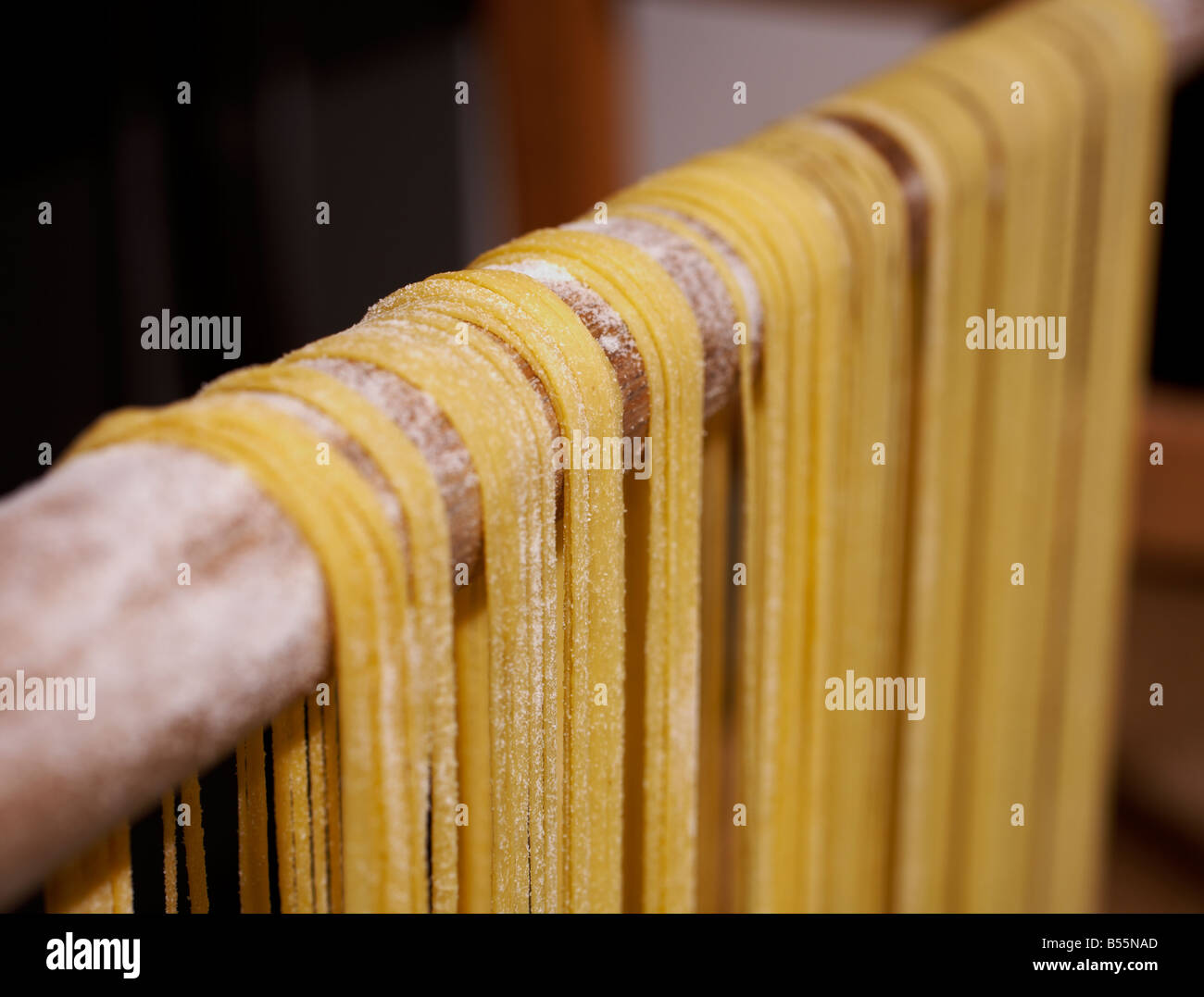 Recién hechas de pasta de huevo colgando sobre el secado de MANGO ESCOBA Foto de stock