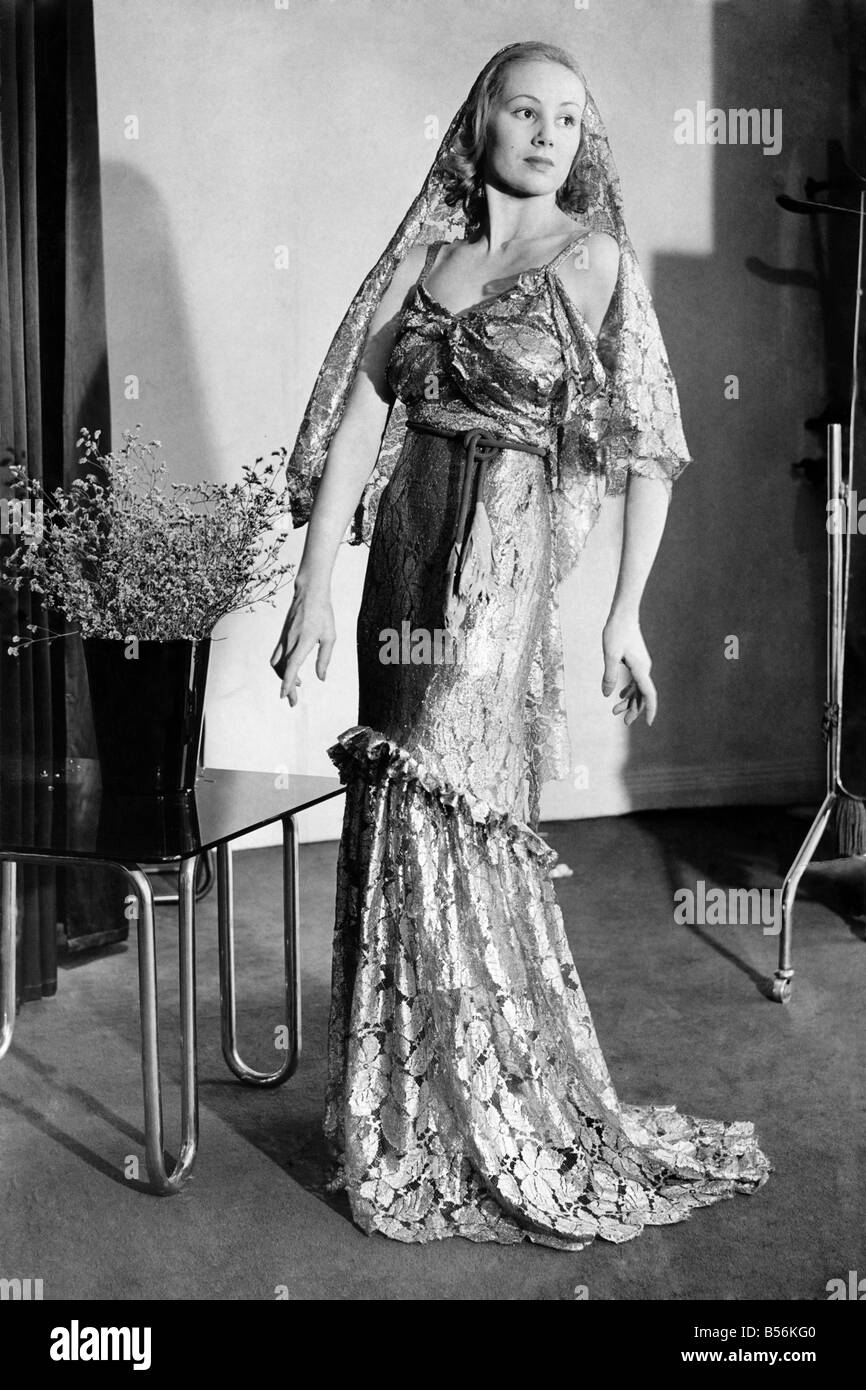 La ropa. Vale un millón. Vestido de Noche de puntilla dorada con cabeza vestido del mismo material fijado en el hombro, sari moda. Abr 193 Foto de stock