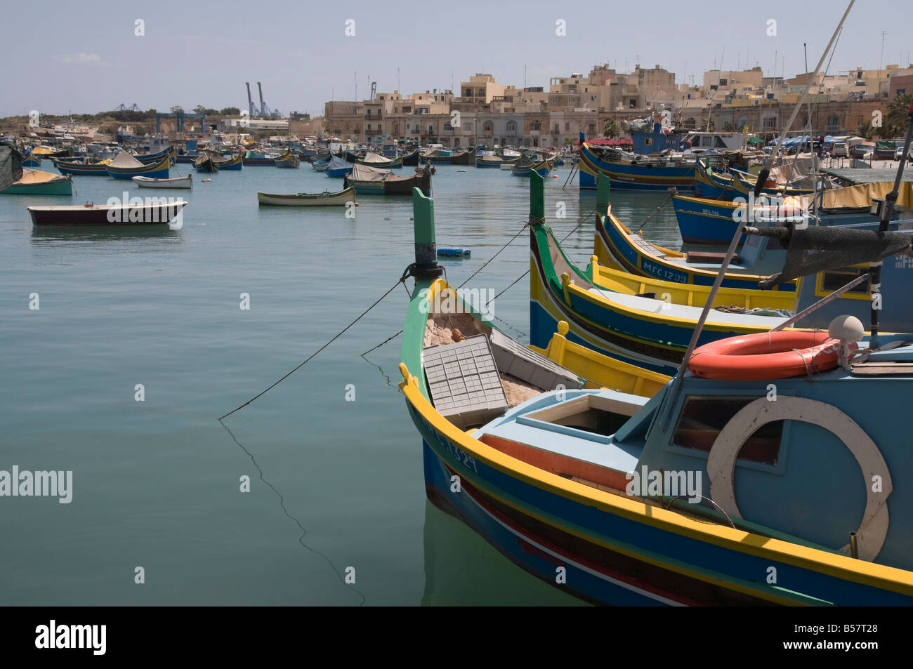 Coloridos barcos de pesca llamado Luzzus en el pueblo pesquero de Marsaxlokk, Malta, el Mediterráneo, Europa Foto de stock
