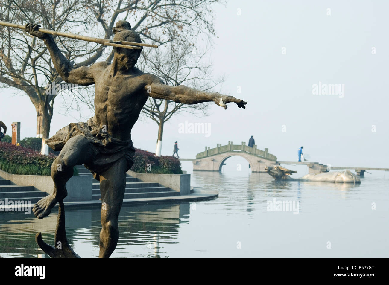Estatua de un pescador lanza en las aguas del Lago del Oeste, en Hangzhou, Provincia de Zhejiang, China, Asia Foto de stock