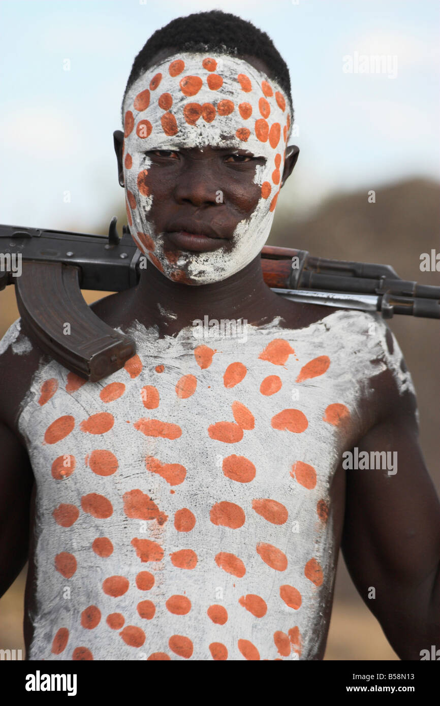 Aldea Kolcho, Karo hombre con body painting, con fusiles Kalashnikov colgada sobre su hombro, bajar el valle de Omo, Etiopía Foto de stock