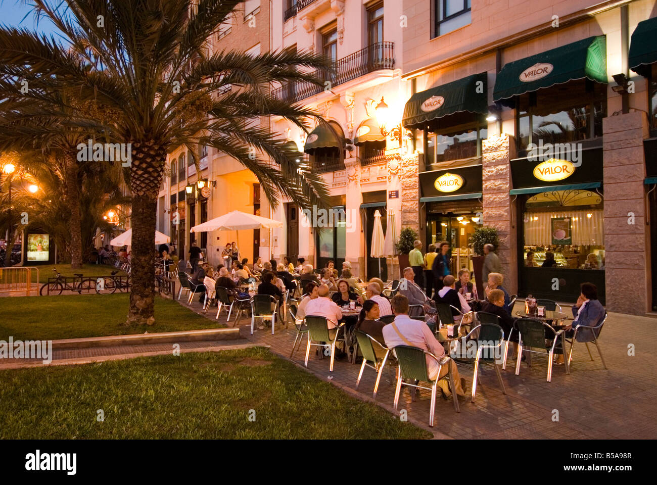 Gente sentada fuera de un bar animado, en la Plaza de la Reina en el centro histórico de la ciudad de El Carmen de Valencia España Foto de stock