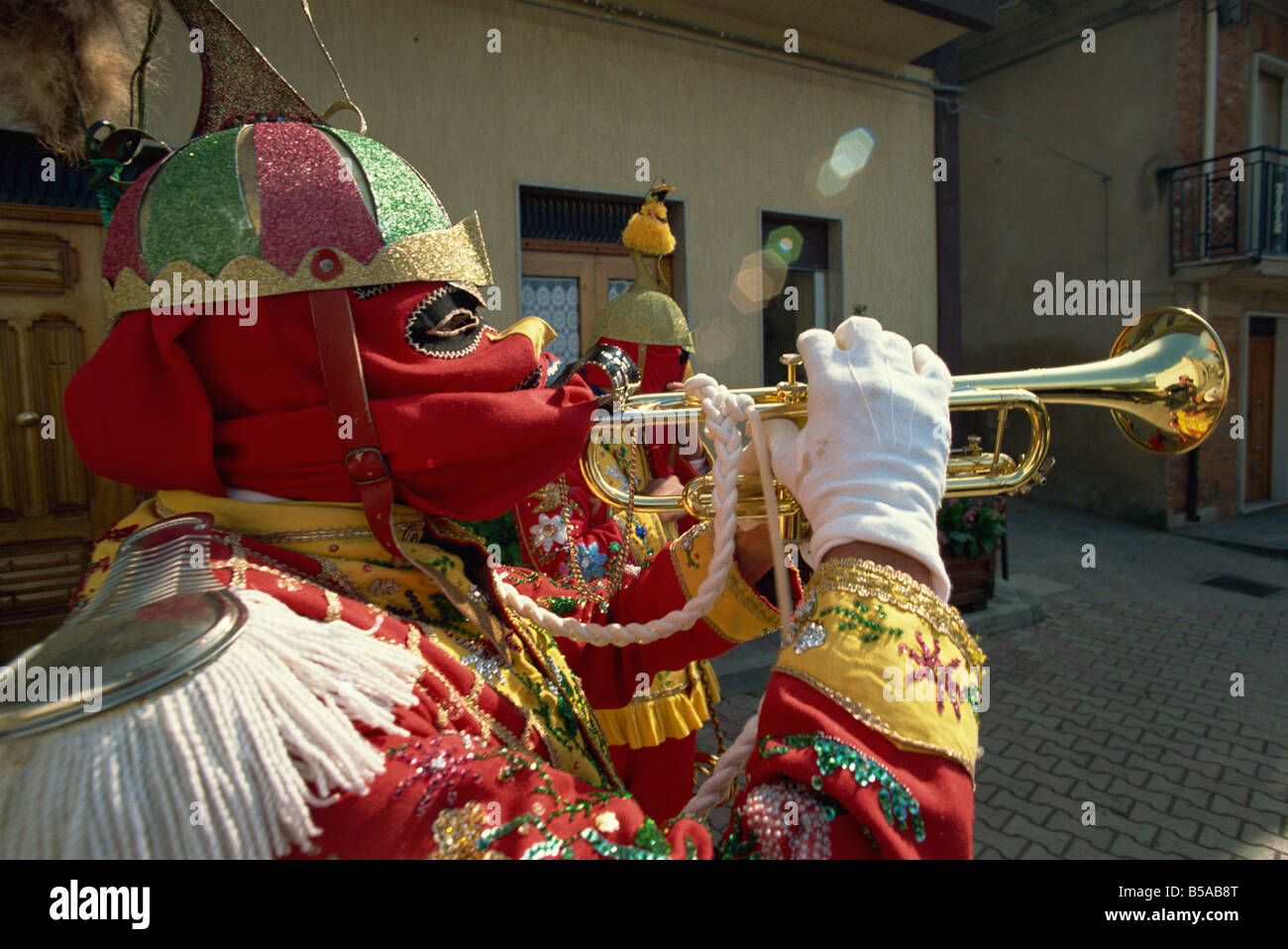 Trompetista en traje rojo y la máscara se celebra la Fiesta de los judíos, en la aldea de lombarda de SAN FRATELLO, en Sicilia, Italia Foto de stock