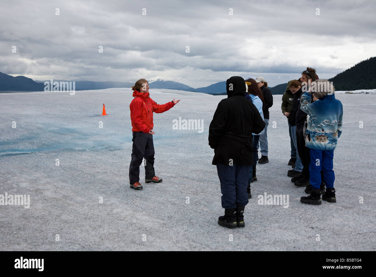 Guía de turismo en la parte superior del glaciar de Mendenhall, cerca de Juneau Alaska enseña y entretiene a los turistas. Foto de stock