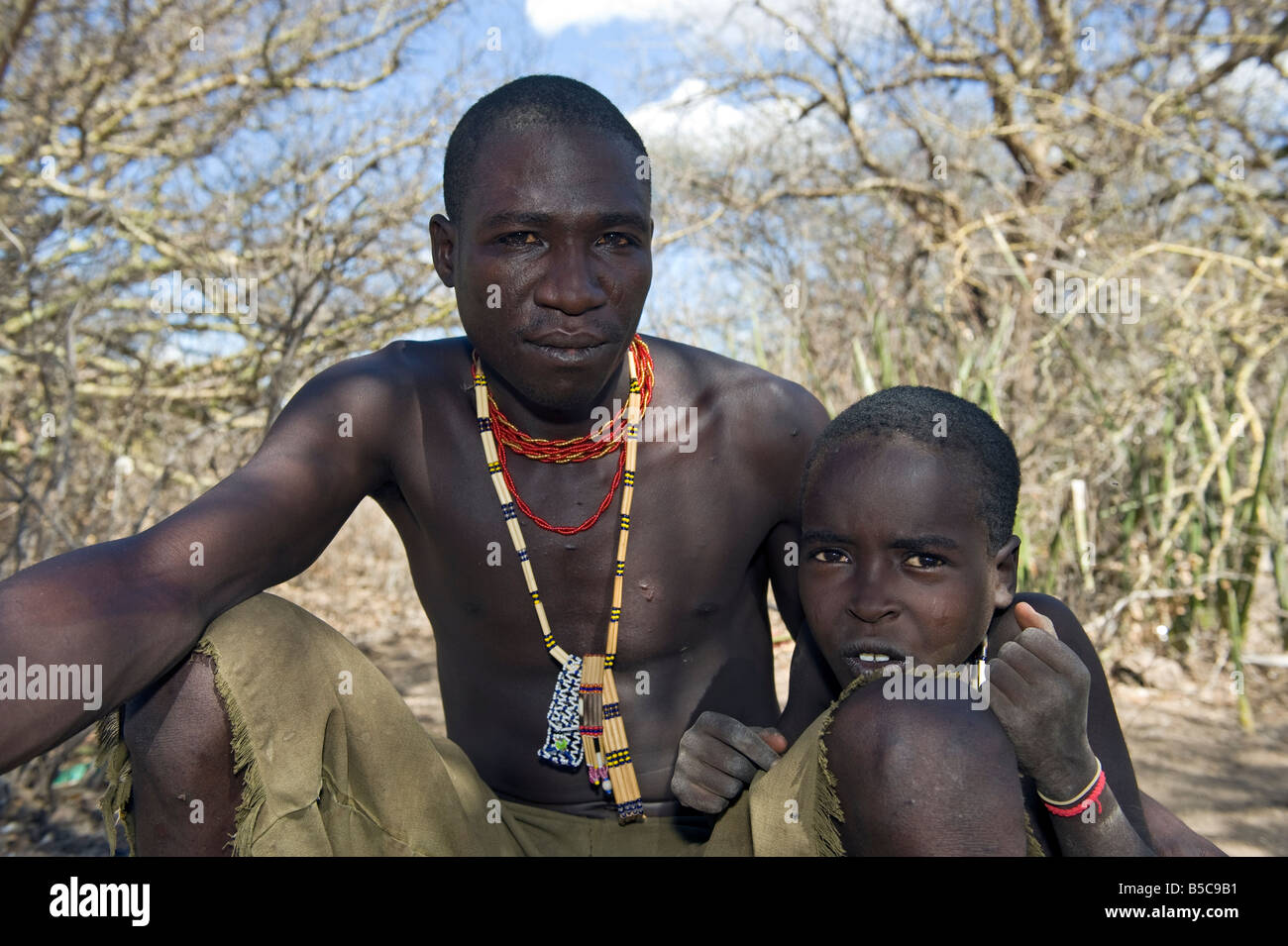 Un hombre de la tribu Hadza con su hijo el lago Eyasi de Tanzania Foto de stock