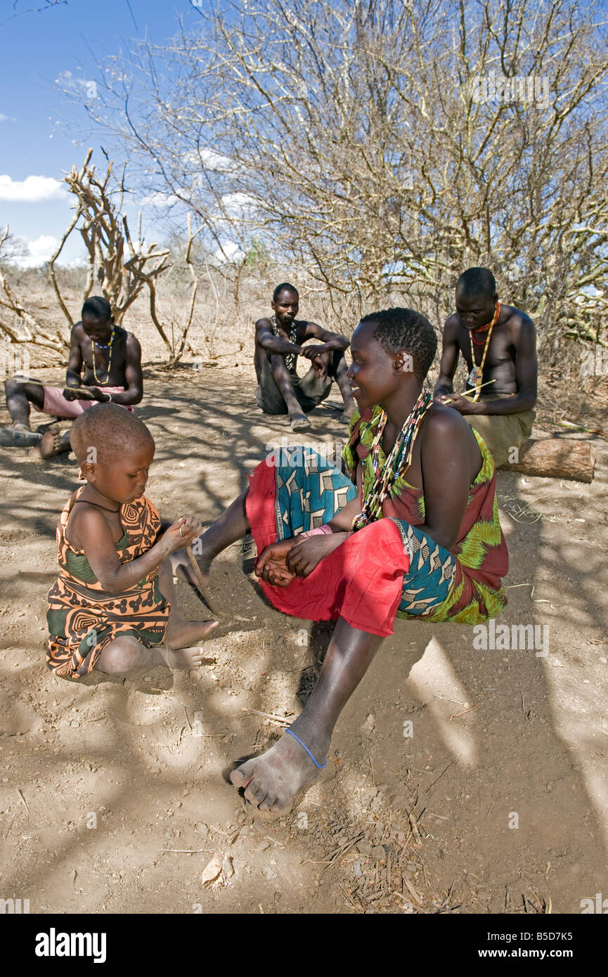 Un niño con su madre y los miembros de la tribu Hadza el lago Eyasi de Tanzania Foto de stock