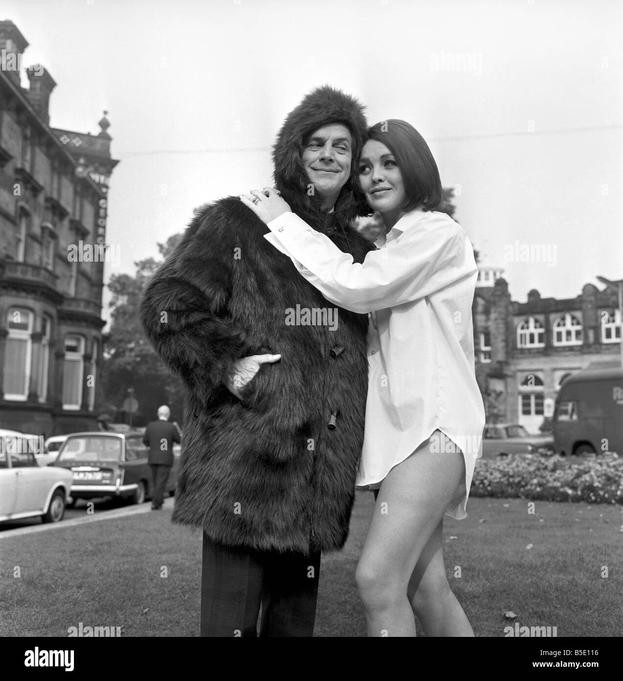 Mens moda: Rodney Lovick vistiendo un oso la chaqueta para hombres y obteniendo un abrazo desde niña modelo Ruth Russell, 23, de Catterick, Yorks, quién lleva un blanco más blanco que la camiseta Tern-Consulate dos dobles. Septiembre de 1966 W9262-004 Foto de stock