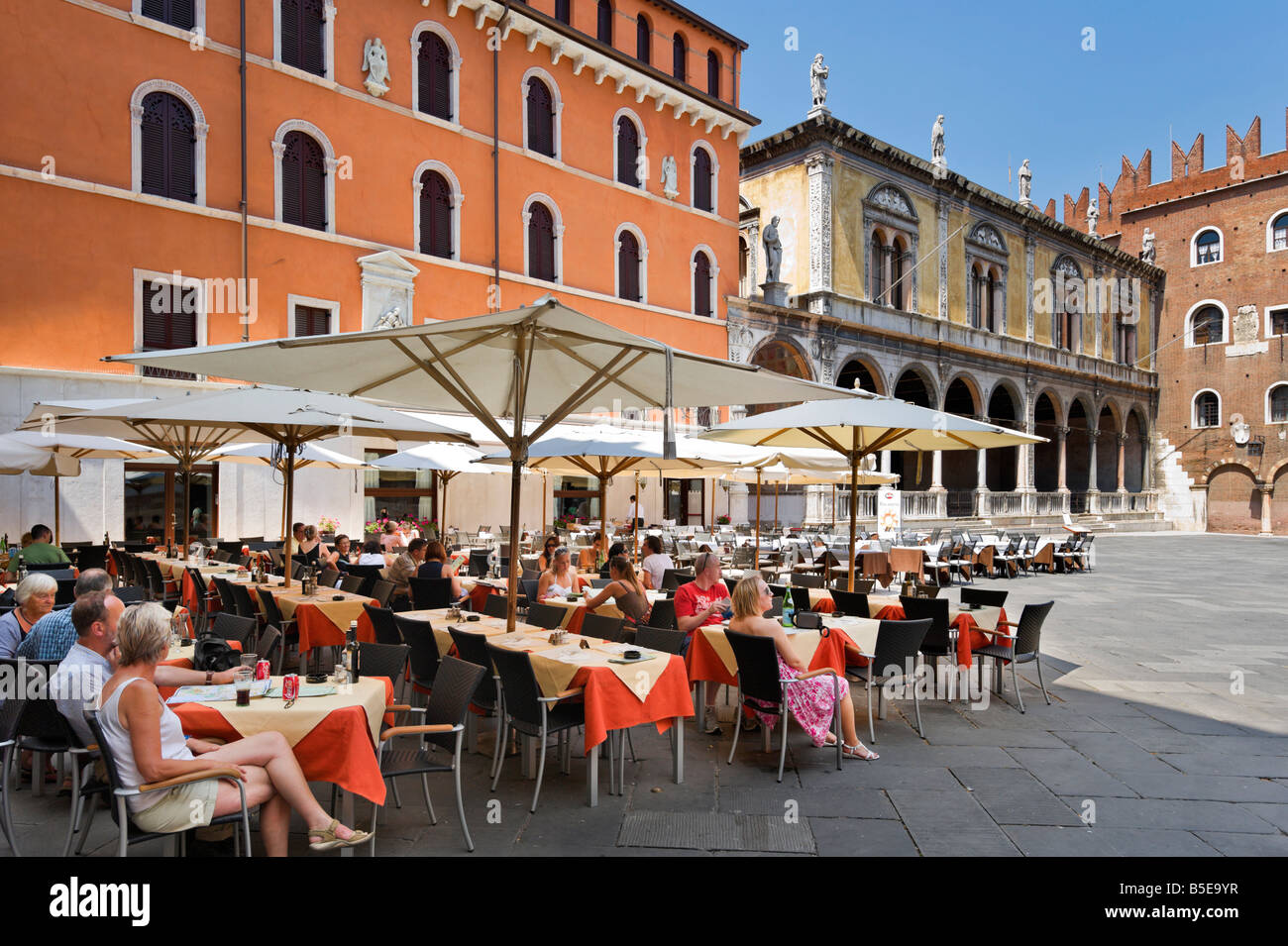 Caffe restaurante Dante en la Piazza dei Signori (con la Loggia del Consiglio y el Palazzo degli Scaligeri detrás), Verona, Italia Foto de stock