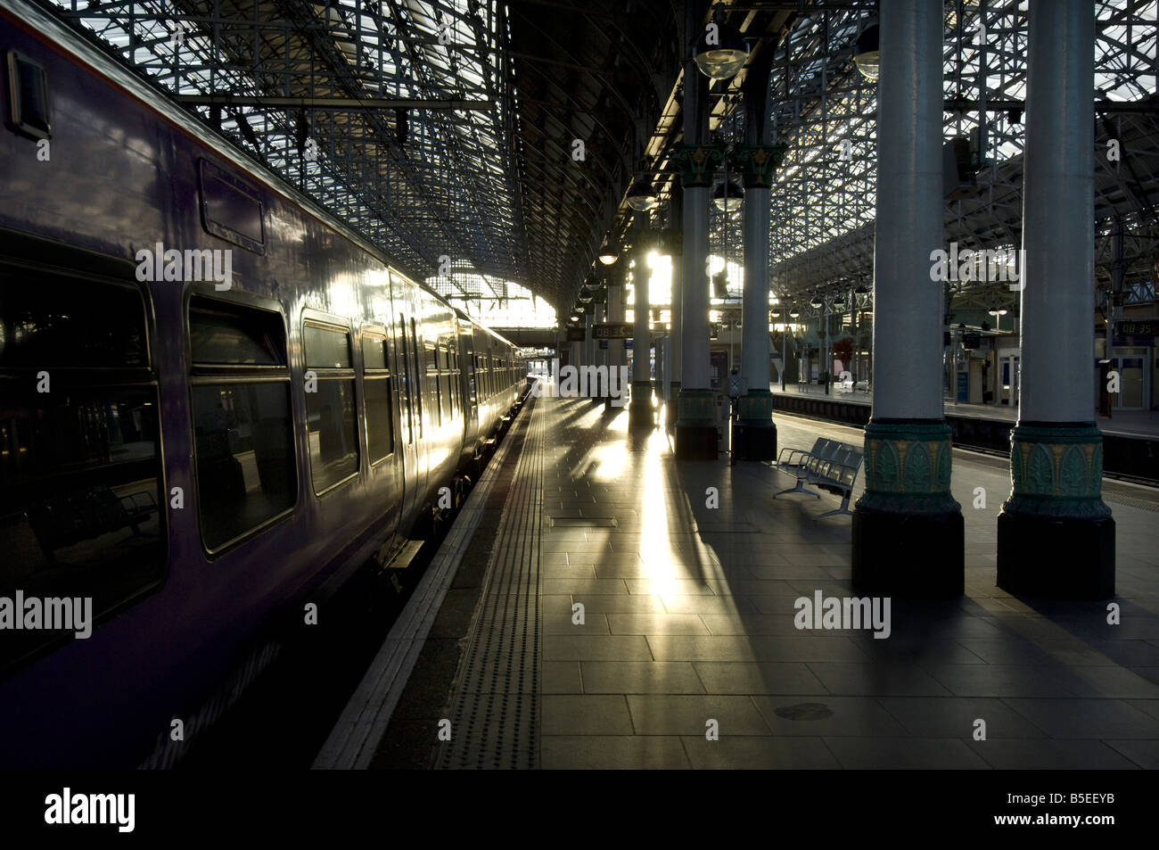 Un tren del norte en la estación de tren Manchester Piccadilly al amanecer como la jornada de trabajo comienza. Foto de stock