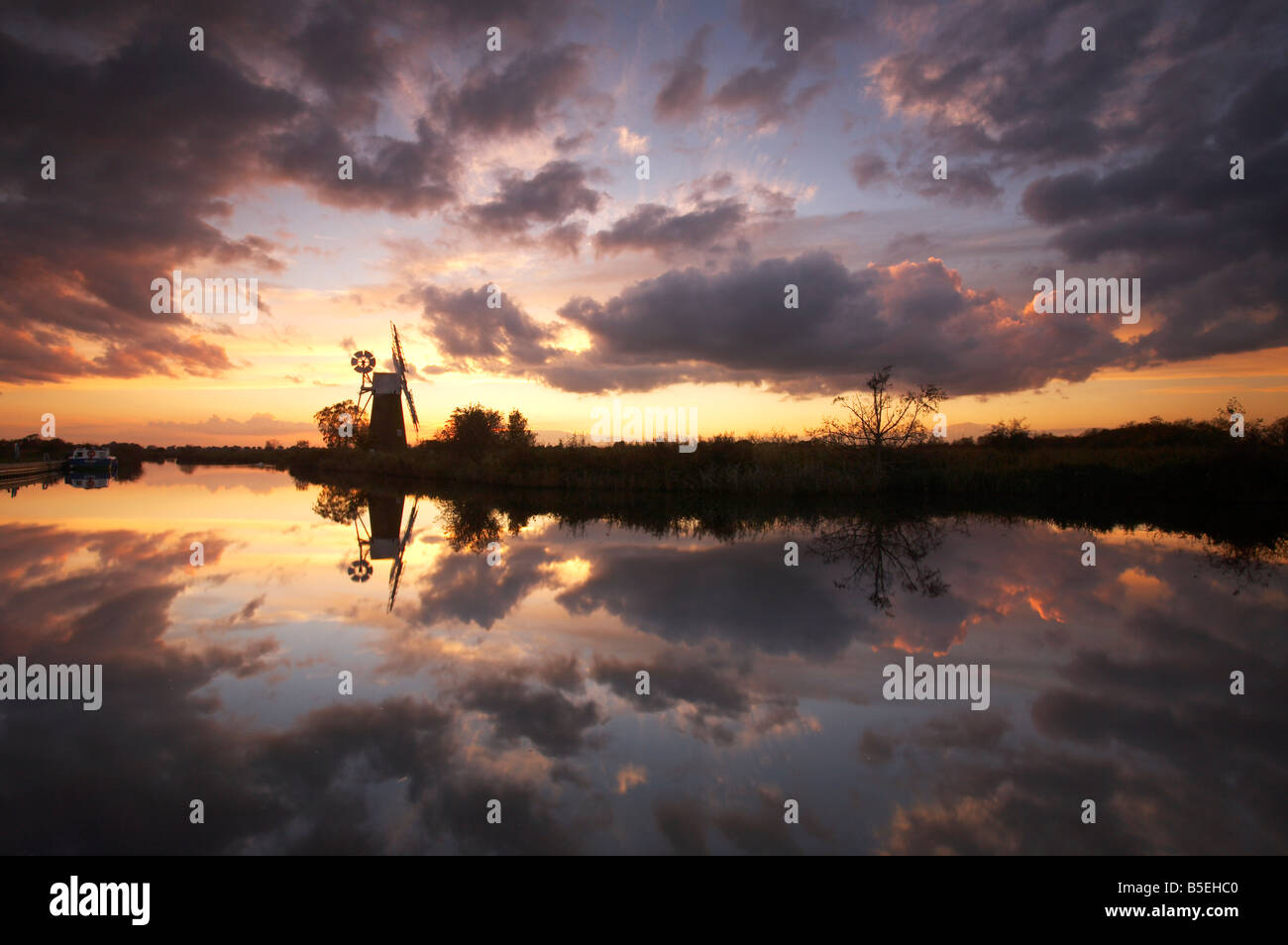 Espectacular atardecer reflejándose en el río Hormiga en el Norfolk Broads, REINO UNIDO Foto de stock