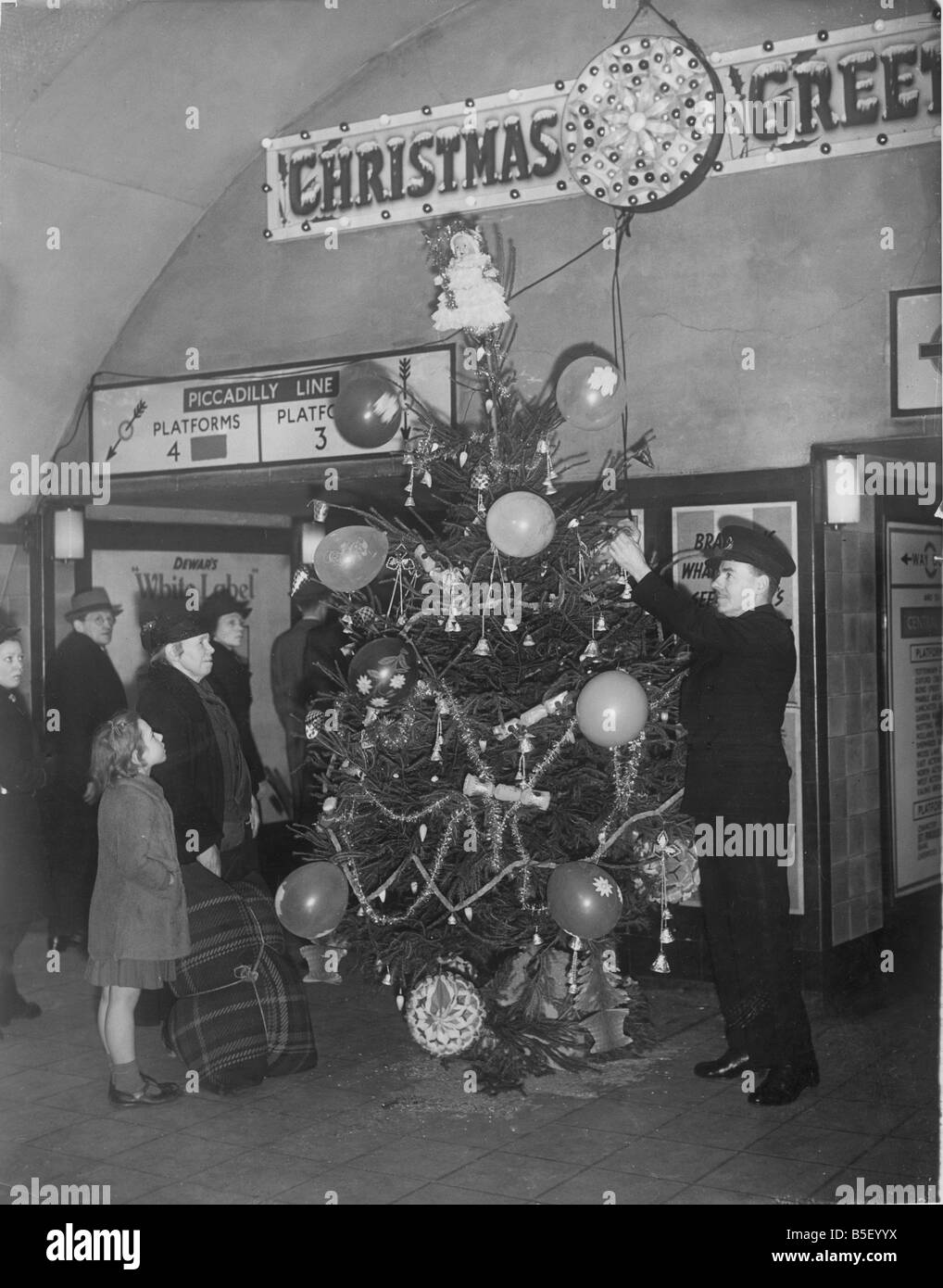 Un guardia de ferrocarril subterráneo Decorar un árbol de Navidad en la  estación de metro de Holburn durante la Segunda Guerra  Mundial&#10;Diciembre de 1940 Fotografía de stock - Alamy