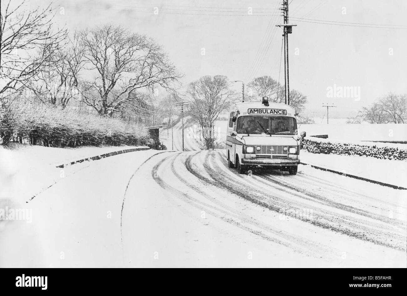 Una ambulancia acelera a una llamada de emergencia en la carretera Chopwell Greenside hasta en la nieve. Foto de stock
