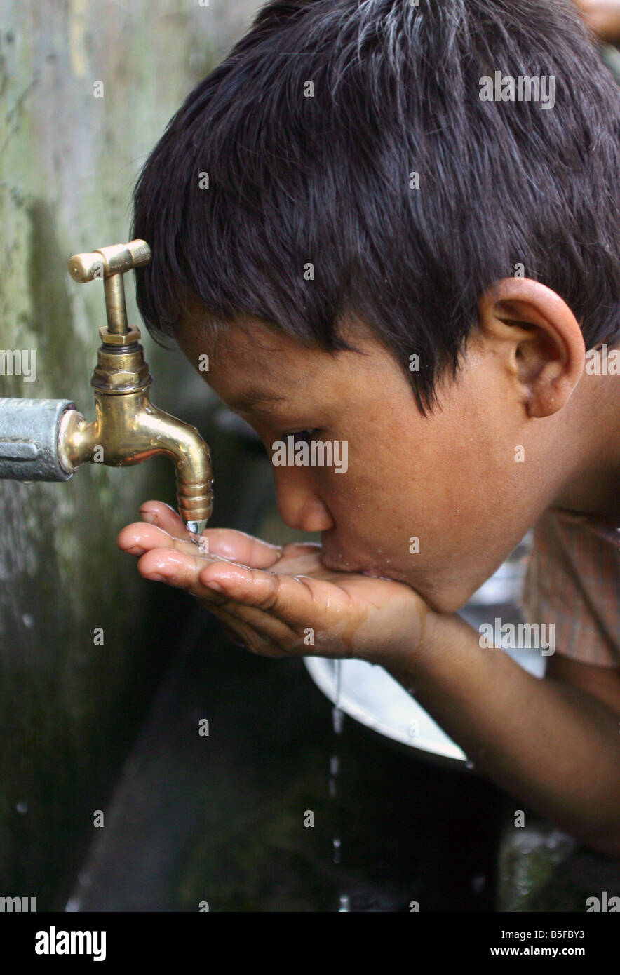 Nepal: niño bebe de un waterpipe Foto de stock