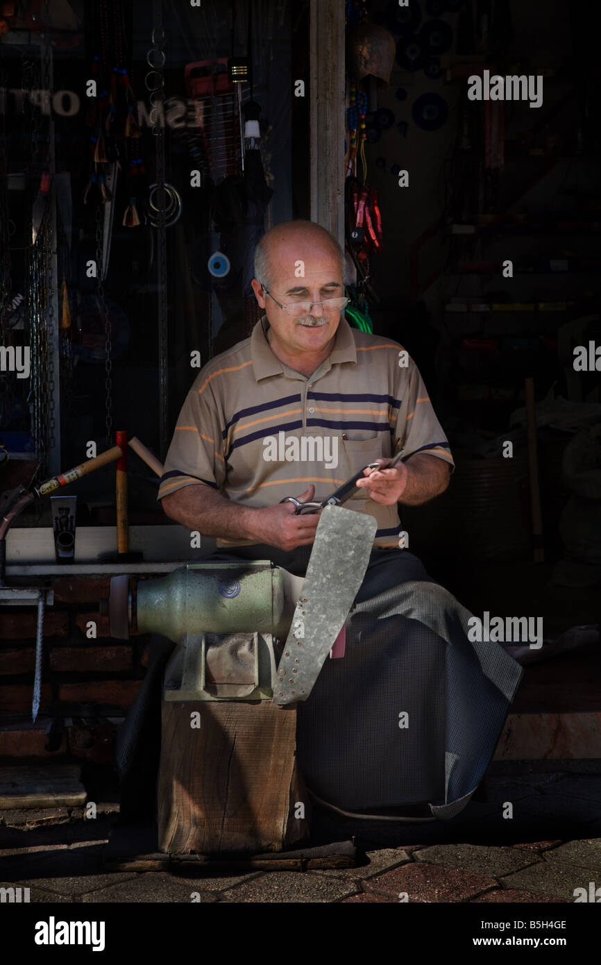 Un zapato de cuero de corte y fresado reparador fuera de su tienda en Fethiye, Turquía Foto de stock