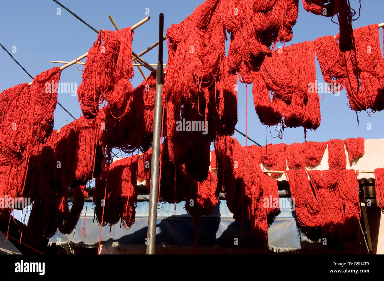 Lanas teñidas de rojo se cuelga a secar sobre el mercado en Marakech, Marruecos. Foto de stock