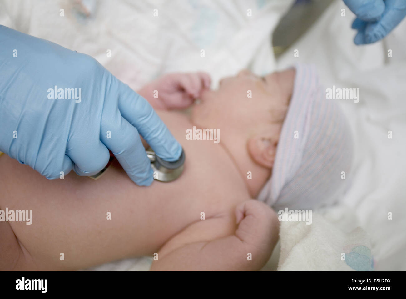 Un neonatal que escucha el corazón de un recién nacido con un estetoscopio en el hospital Un neonatal que escucha el corazón de un recién nacido con un estetoscopio en el hospital