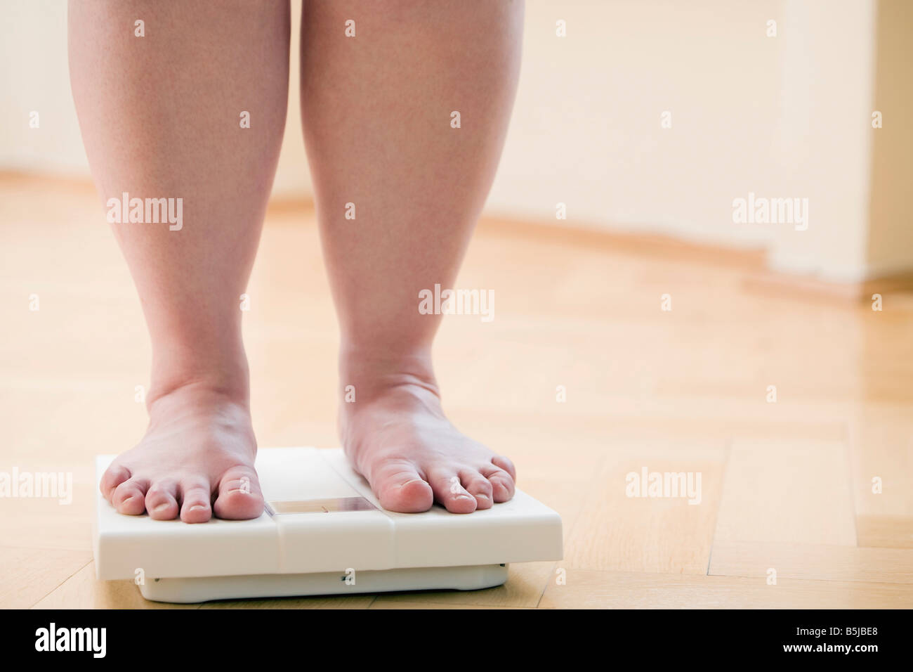 Pies femeninos en la balanza con la medida del peso corporal