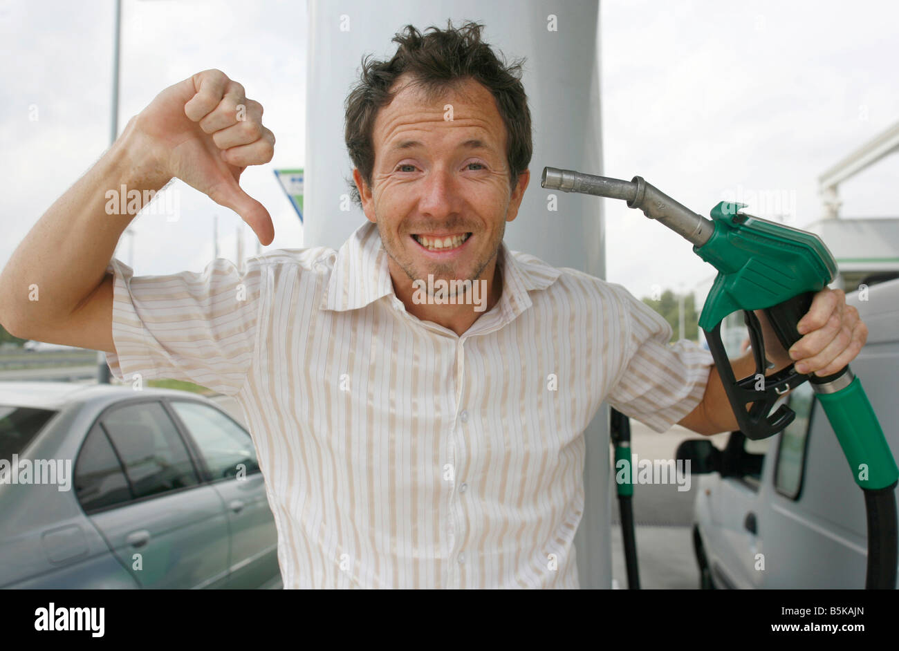El hombre feliz acerca de la disminución de los precios de la gasolina Foto de stock