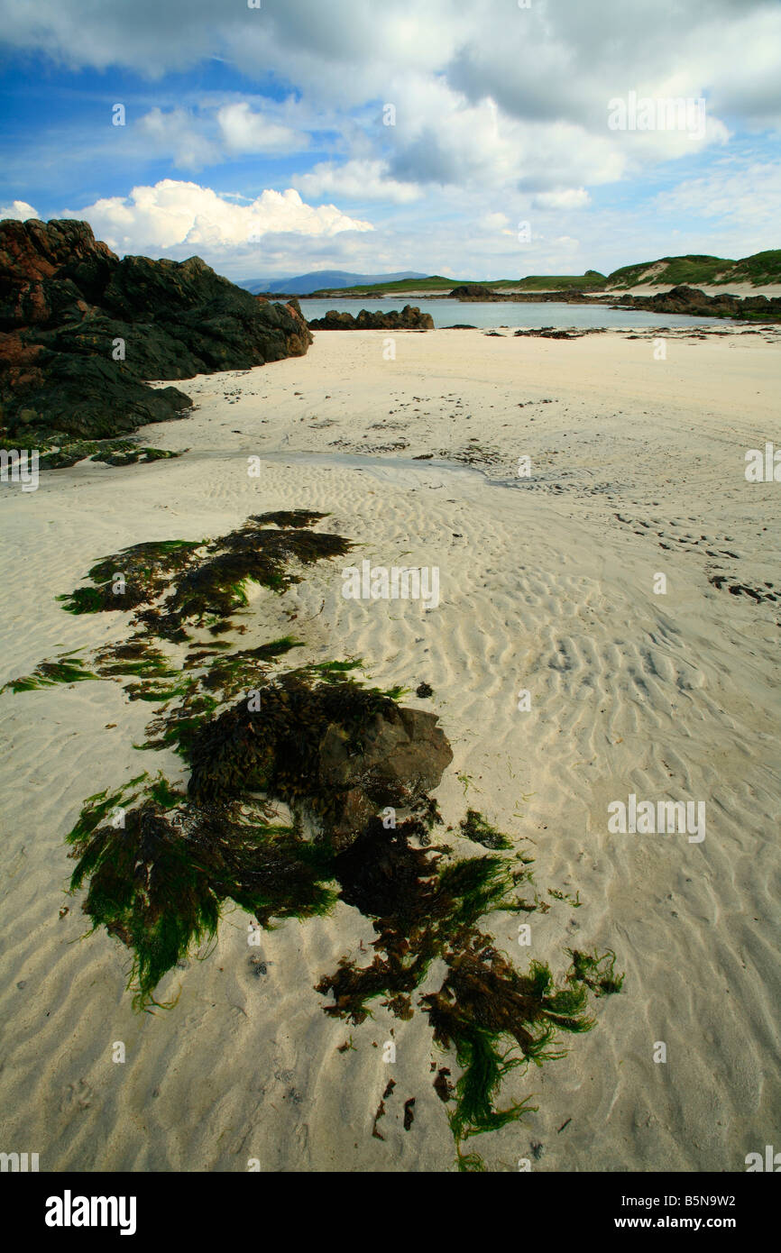 Vista de una playa de arena blanca en la costa oeste de la isla de Iona en Escocia con la Isle Of Mull en la distancia Foto de stock